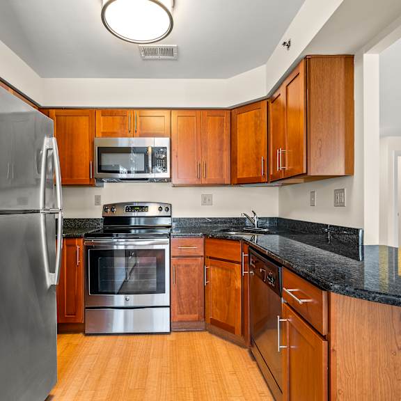 a kitchen with a black counter top and wooden cabinets.