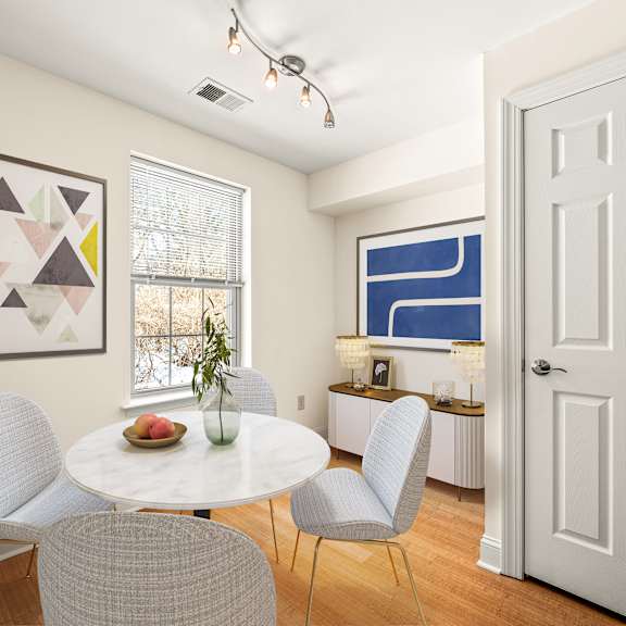 a dining room with a white table and chairs.