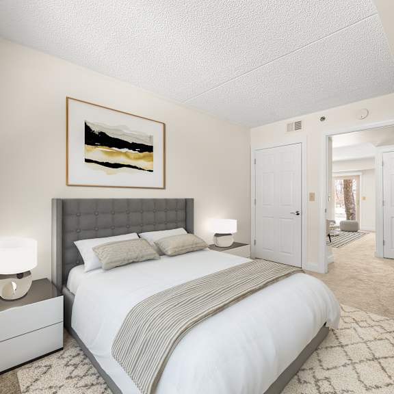 a bedroom with a large bed, a nightstand with a lamp, and a painting on the wall.
