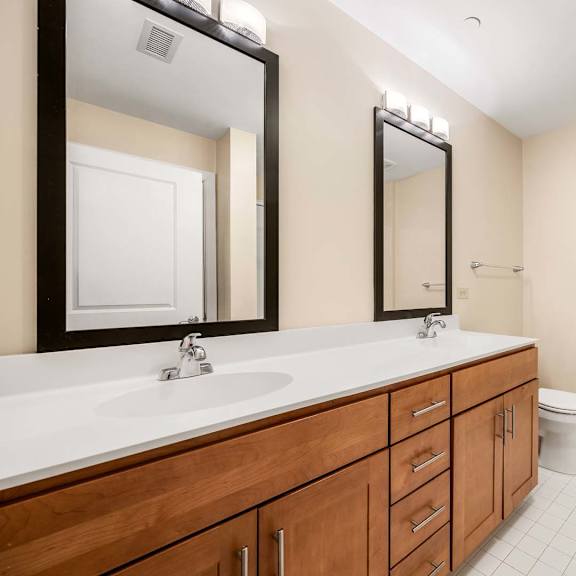 a bathroom with a toilet, sink, and mirror.