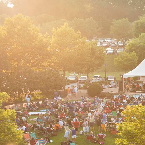a large crowd of people are gathered in a park for an event.