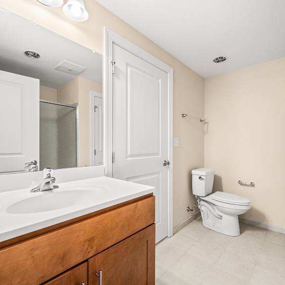 a white sink in a bathroom with a toilet in the background.