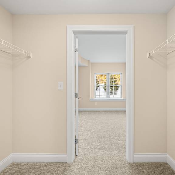 a room with a carpeted floor and a doorway leading to another room.