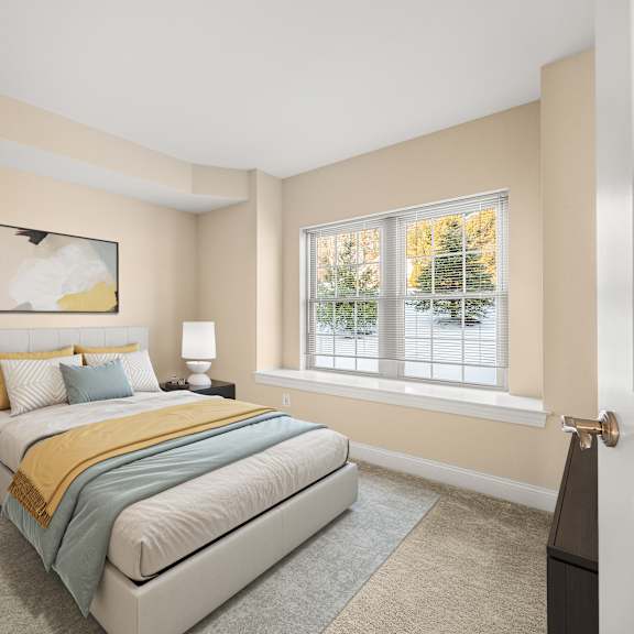 a bedroom with a bed, nightstand, and window.