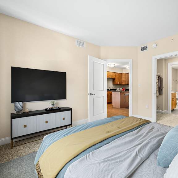 a bedroom with a bed, a television, and a cabinet.