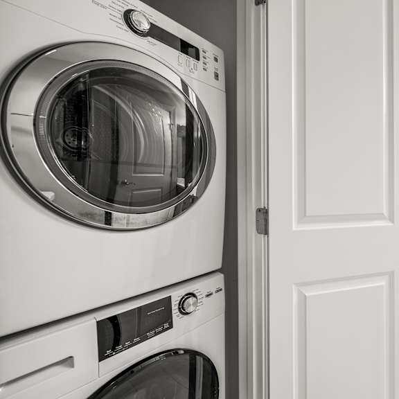 a washing machine is in the foreground of a modern laundry room.
