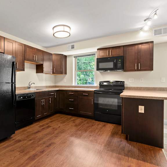 a kitchen with black appliances and wooden cabinets