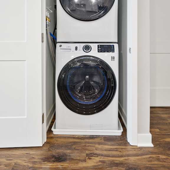 a white washing machine is in a cabinet.