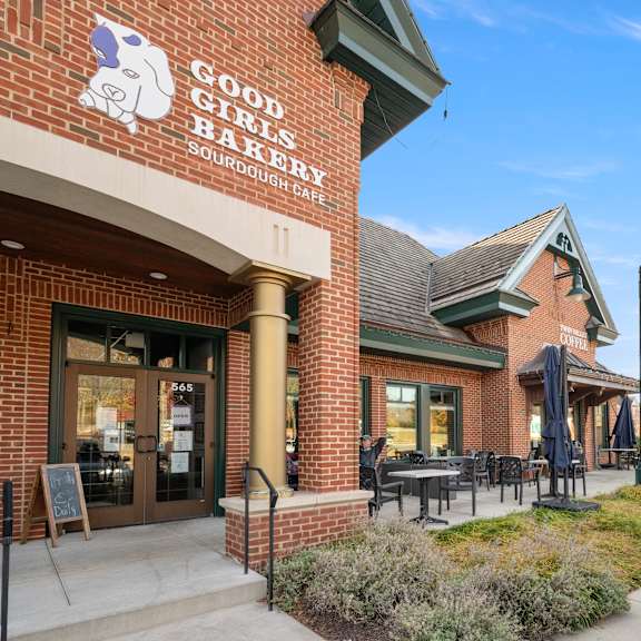 a brick building with a sign that says good girls bake sourdough cafe.