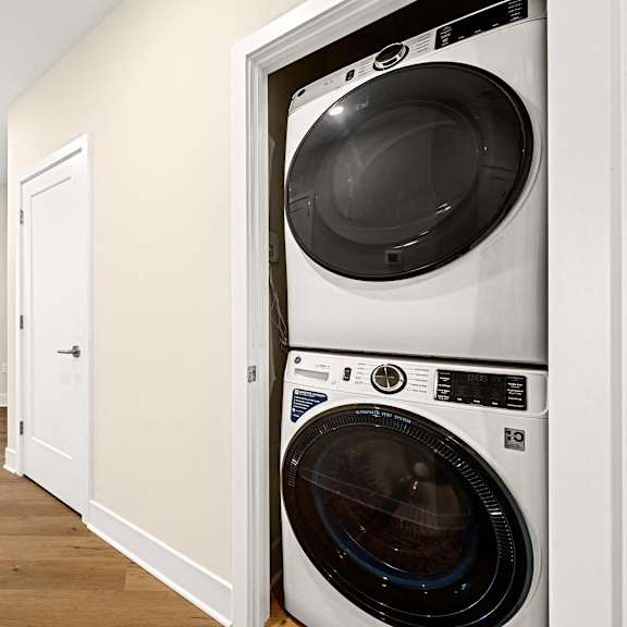 bright laundry room with a washing machine, dryer, and clean white finishes at hamilton at eagleview in exton, pa