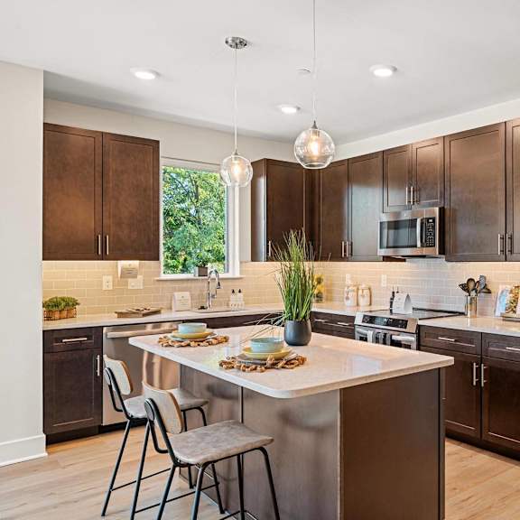 modern kitchen featuring stainless steel appliances, elegant wooden cabinetry, and granite countertops at hamilton at eagleview in exton, pa