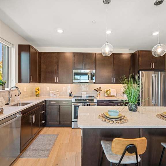 modern kitchen with stainless steel appliances, sleek wooden cabinetry, and granite countertops at hamilton at eagleview in exton, pa