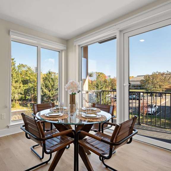bright dining area with large windows, a stylish table, and modern seating at hamilton at eagleview in exton, pa