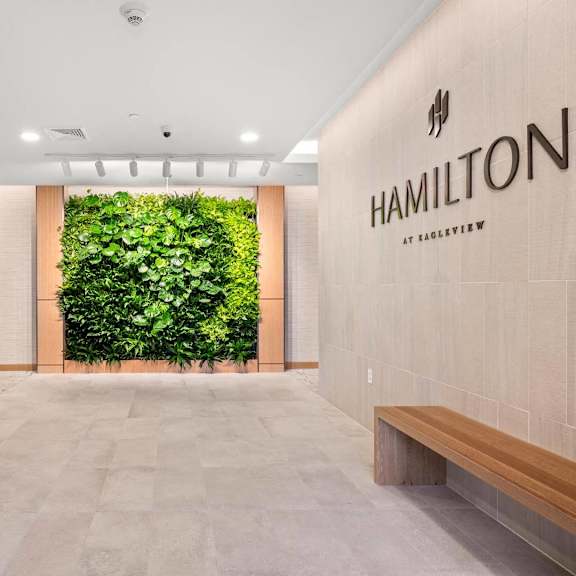 hotel lobby featuring a striking large green wall in the background, creating a vibrant and welcoming atmosphere