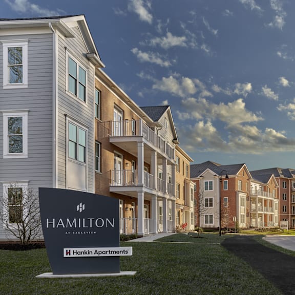 the hamilton at eagleview sign stands proudly in front of the apartment buildings, welcoming residents to the community in exton, pa