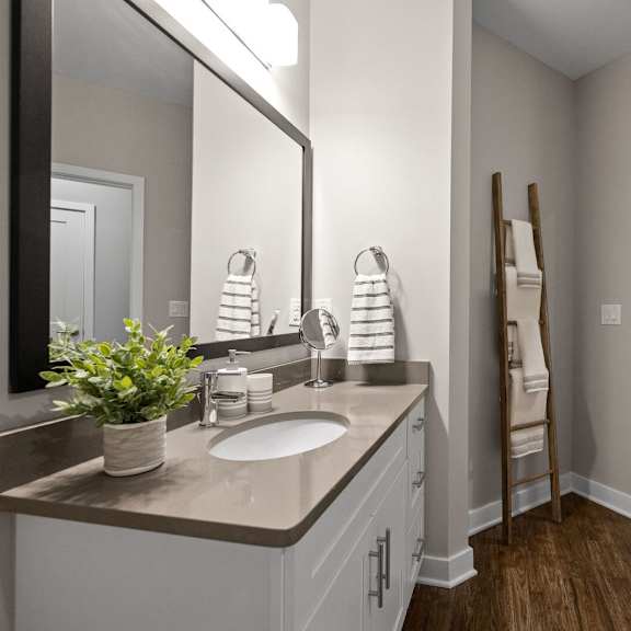 modern bathroom with a sink, mirror, and doorway at hamilton at eagleview, exton, pa 19341