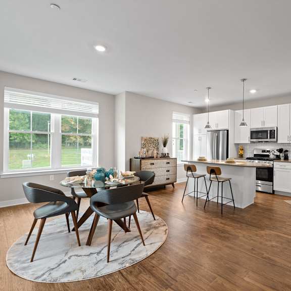 open-concept kitchen with a central island, dining room table, and chairs at hamilton at eagleview in exton, pa