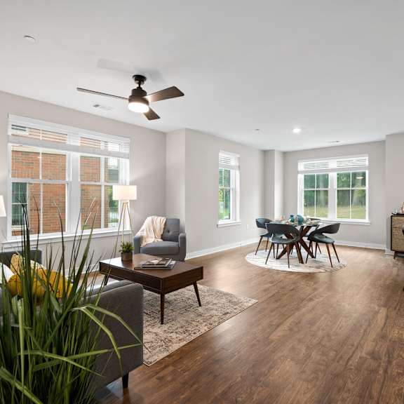 spacious living room featuring a comfortable couch, a stylish table, and a ceiling fan at hamilton at eagleview in exton, pa