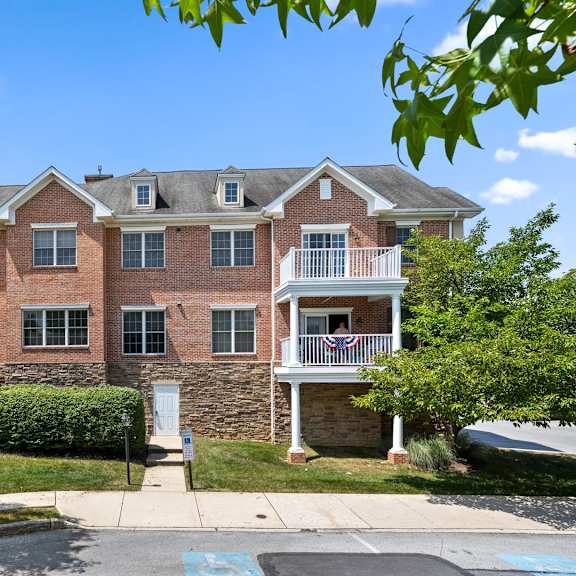 charming red brick apartment building with a flag displayed on the balcony at claremont apartments in exton, pa
