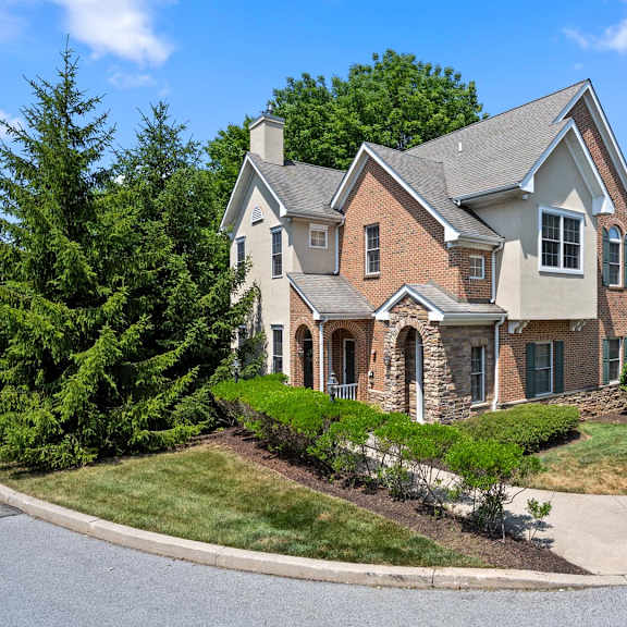 spacious house featuring a grey roof and elegant stone pillar accents at claremont, exton, pa