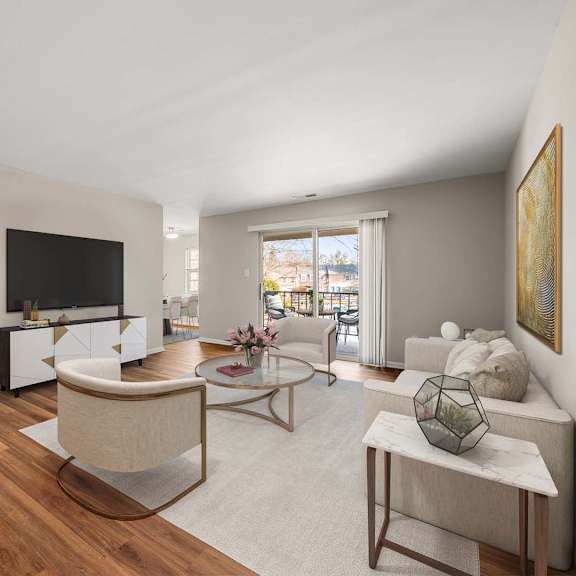 a living room with a white couch, a coffee table, and a television.