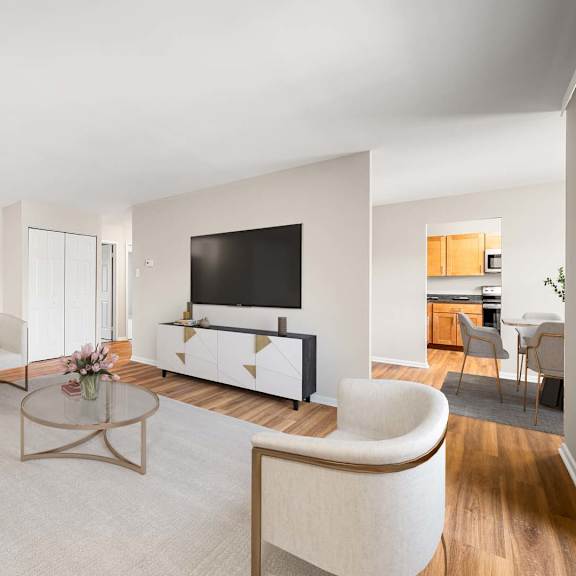 a modern living room with a white sofa, a coffee table, and a television.