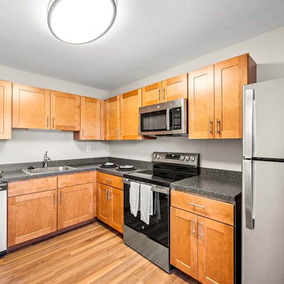 a kitchen with wooden cabinets and stainless steel appliances.