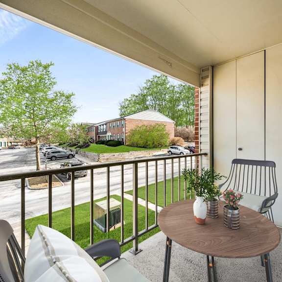 a balcony with a table and chairs overlooking a street.