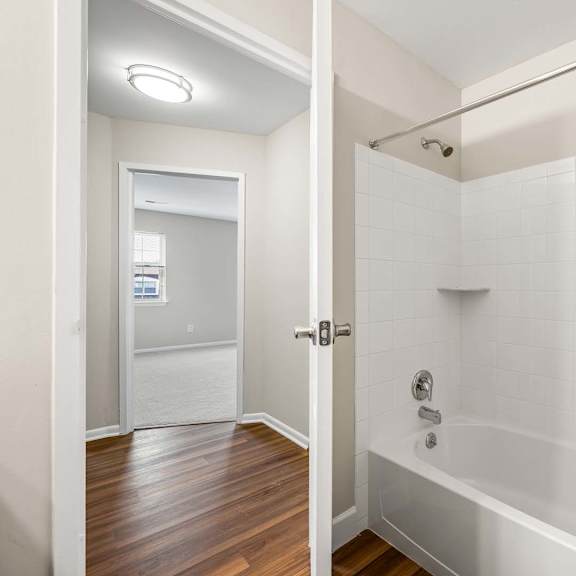 a bathroom with a shower and a wooden floor.
