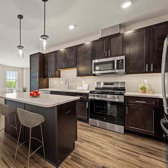 a modern kitchen with dark wood cabinets and a center island.