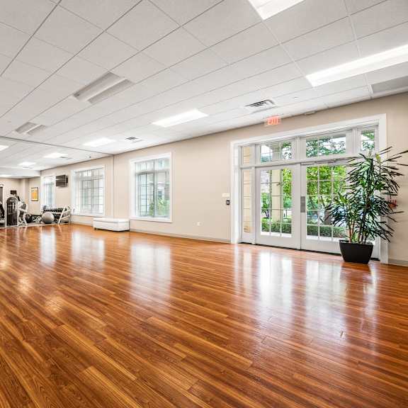 a spacious room with wooden floors and white furniture.