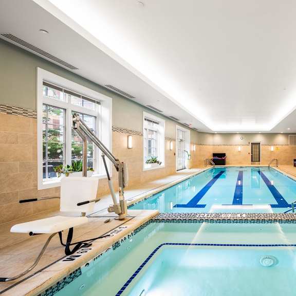 a large indoor swimming pool with a diving board and lane markers.