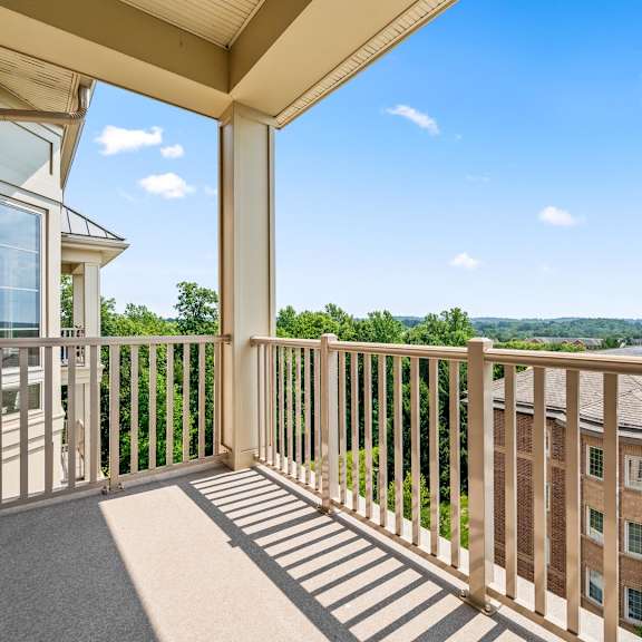 a balcony with a view of the sky and trees.