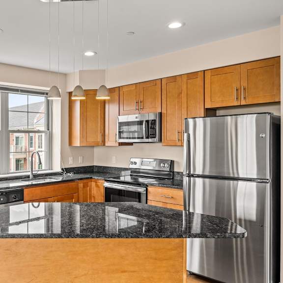 a modern kitchen with wooden cabinets and stainless steel appliances.