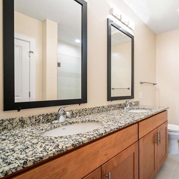 a bathroom with a marble counter top and a walk in shower.
