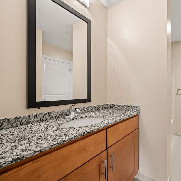 a bathroom with a sink, mirror, and toilet.