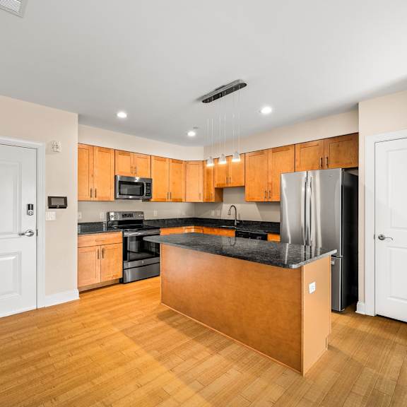 a kitchen with wooden cabinets and a black countertop.