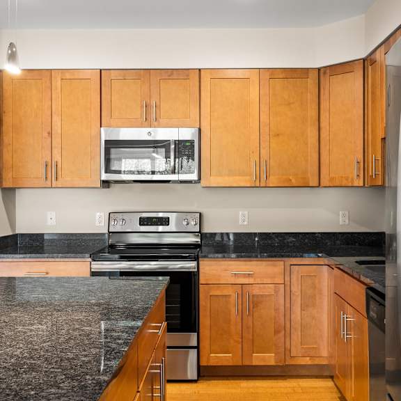a kitchen with wooden cabinets and granite countertops.
