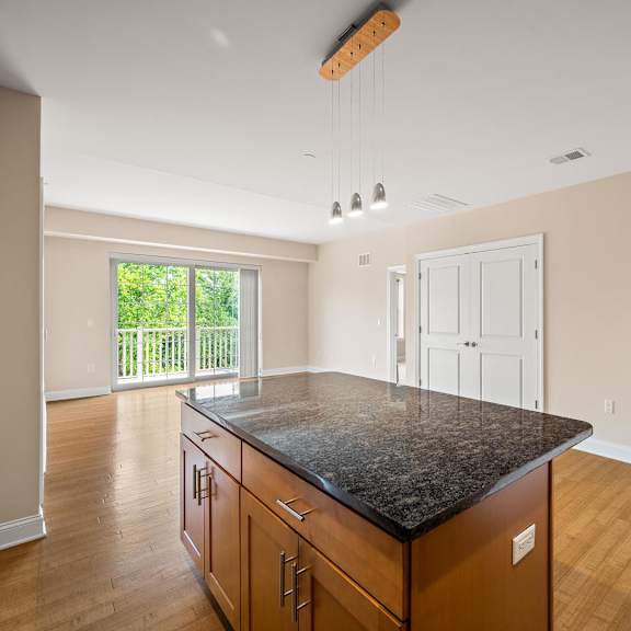 a kitchen with a black granite countertop and wooden cabinets.