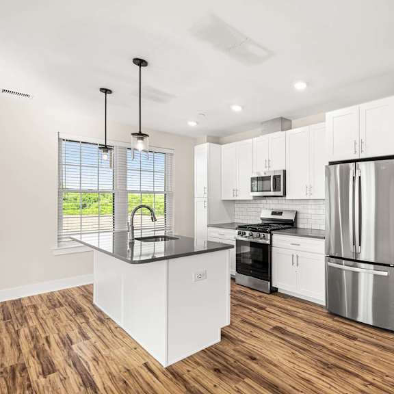 a modern kitchen with white cabinets and stainless steel appliances.