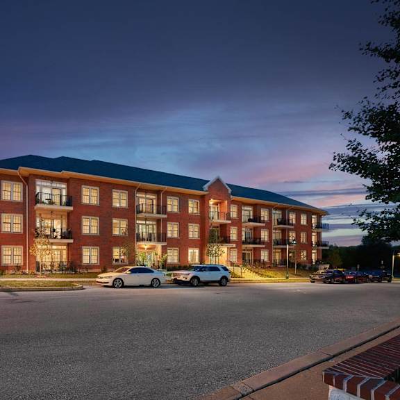 a large red brick building with a parking lot in front.