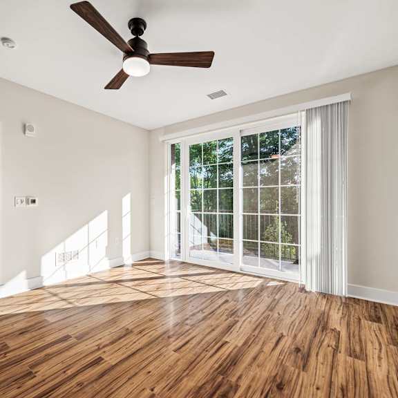 a room with a ceiling fan and a large window.