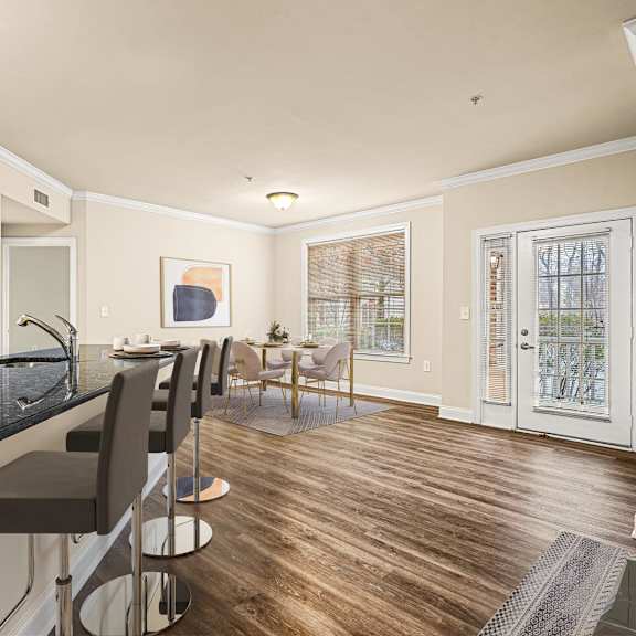 modern kitchen with sleek black countertops, complemented by a dining area featuring a table and chairs at claremont apartments in exton, pa