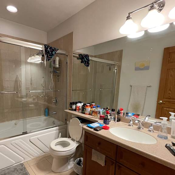 a bathroom with a toilet, sink, and shower.