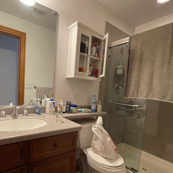 a bathroom with a toilet, sink, and shower.