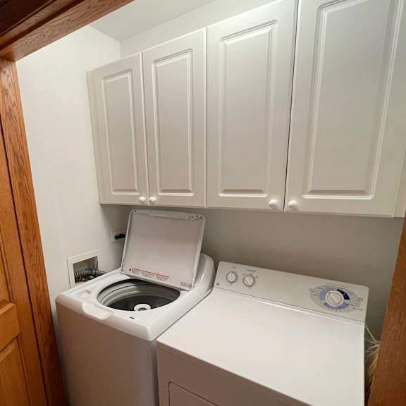a white washing machine and dryer in a small laundry room.