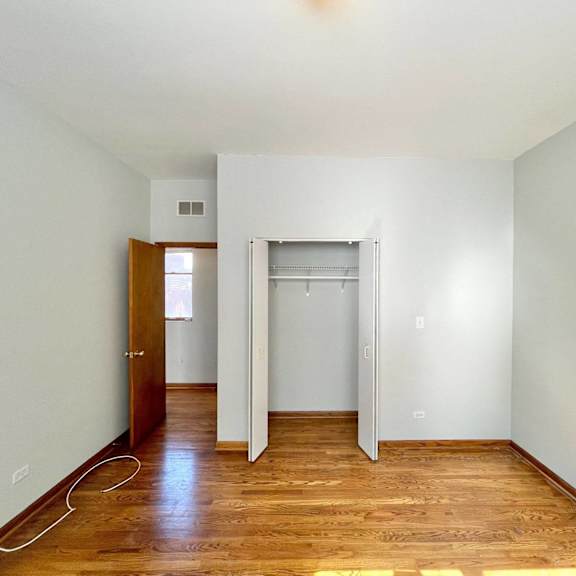 an empty room with wood floors and white walls and a closet