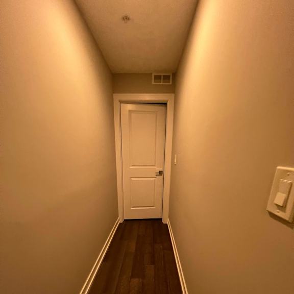 a long hallway with a white door at the end