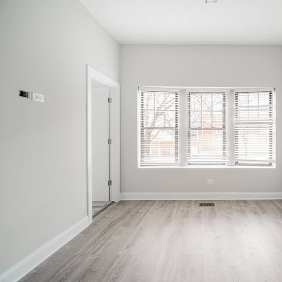an empty room with white walls and a window