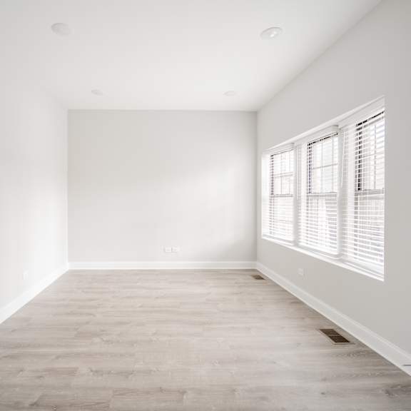 an empty room with white walls and a window